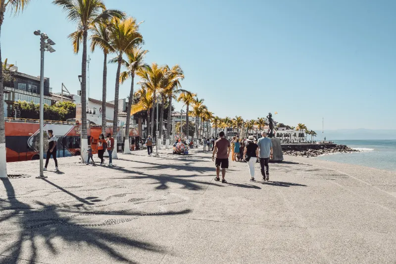 People walking along the beach in Puerto Vallarta, a popular tourist destination in Mexico known for its stunning coastal views.