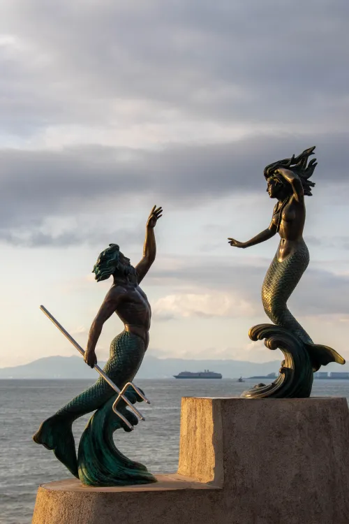 A luxurious statue featuring a mermaid and man with a spear at the Malecon of Puerto Vallarta, a location recommended by investment specialist Miriam Siordia.